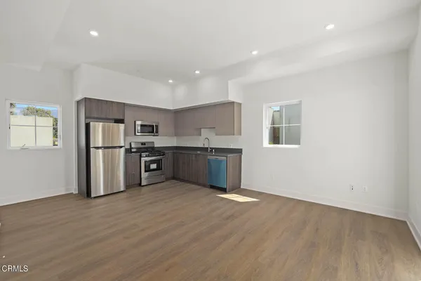 a kitchen with stainless steel appliances granite countertop a refrigerator and a stove top oven