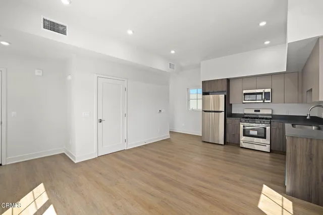 a kitchen with stainless steel appliances a refrigerator and a stove top oven
