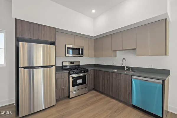 a kitchen with a sink a refrigerator and a stove top oven