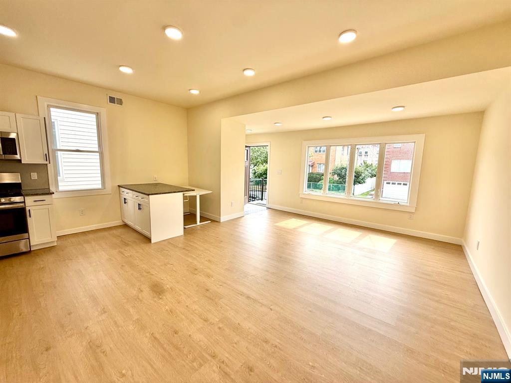 144 Centre Avenue Secaucus, NJ 07094 - Photo 10 of 22 a view of an empty room with a window and wooden floor
