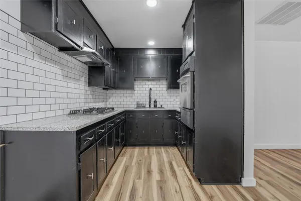 a kitchen with stainless steel appliances a sink dishwasher a stove a microwave oven and cabinets