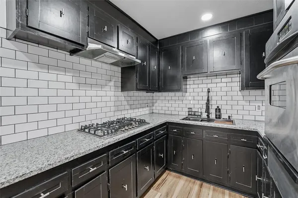 a kitchen with a sink stove and cabinets