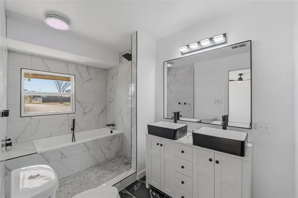 a bathroom with a bathtub sink and mirror