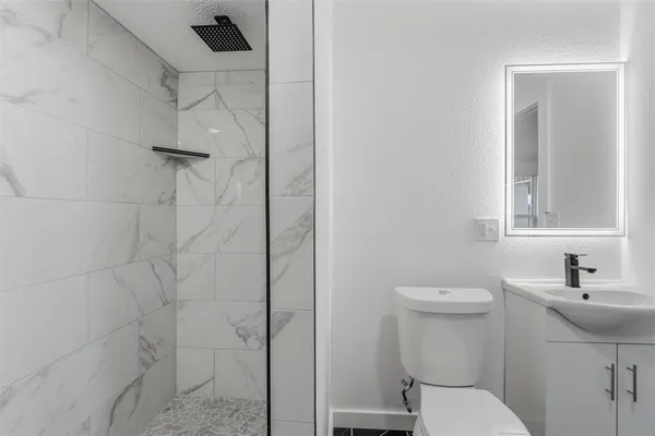 a bathroom with a toilet a sink and mirror