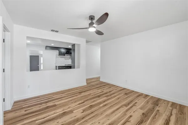 a view of empty room with wooden floor
