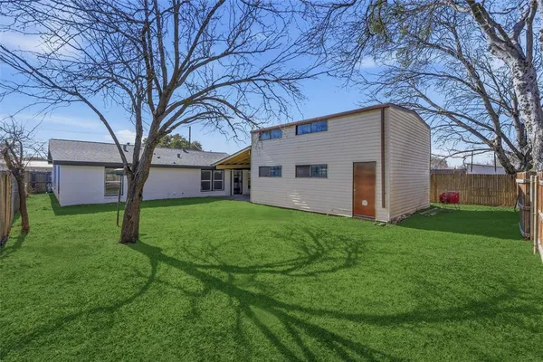 a view of a house with backyard and a tree