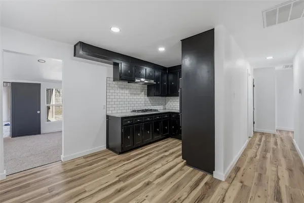 a kitchen with granite countertop a sink stainless steel appliances and cabinets
