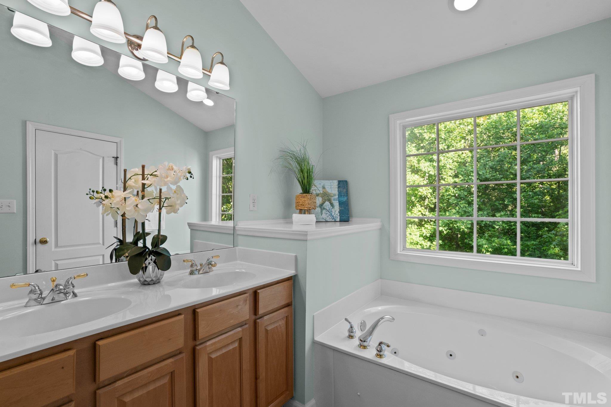 6831 Middleboro Drive Raleigh, NC 27612 - Photo 17 of 32 a bathroom with a bathtub a sink and a mirror