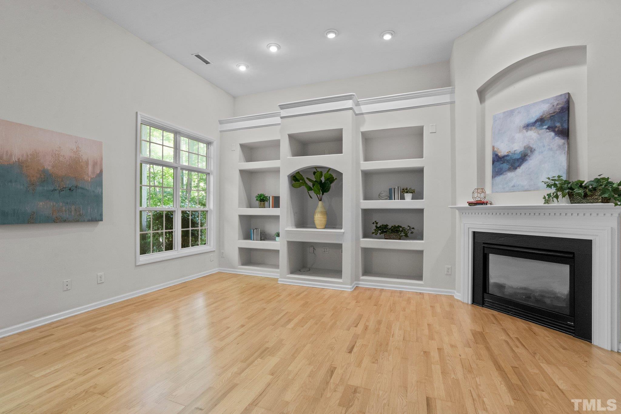 6831 Middleboro Drive Raleigh, NC 27612 - Photo 23 of 32 a big room with windows and fireplace
