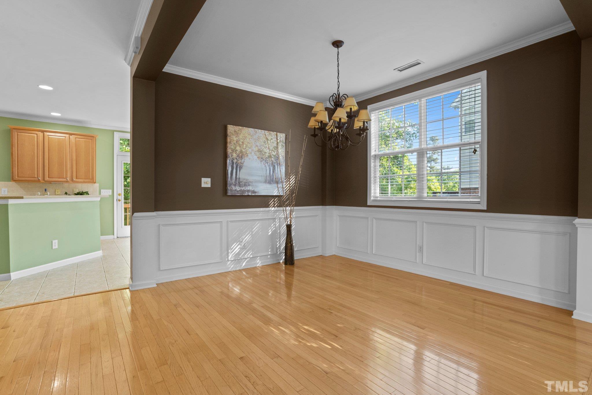 6831 Middleboro Drive Raleigh, NC 27612 - Photo 6 of 32 a view of an empty room with a window and a kitchen view