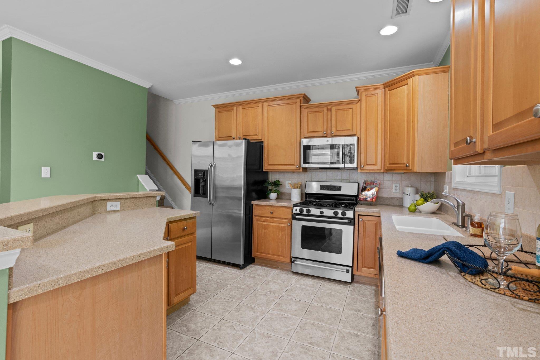 6831 Middleboro Drive Raleigh, NC 27612 - Photo 8 of 32 a kitchen with a refrigerator and a stove top oven