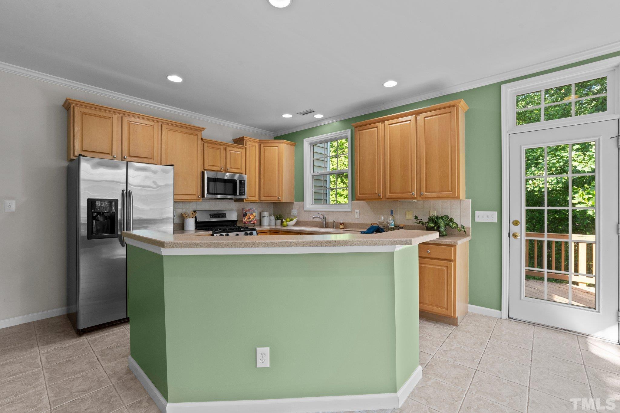6831 Middleboro Drive Raleigh, NC 27612 - Photo 10 of 32 a kitchen with kitchen island a counter top space a sink a refrigerator and a view of living room