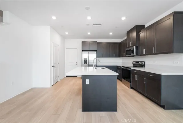 a large kitchen with stainless steel appliances granite countertop a large counter top and a stove top oven