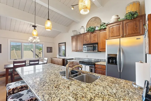 a kitchen with granite countertop a sink stainless steel appliances and cabinets