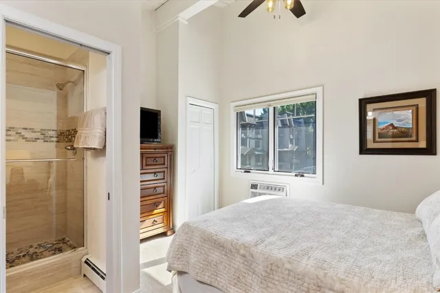 a bedroom with a bed and a flat tv screen on the dresser