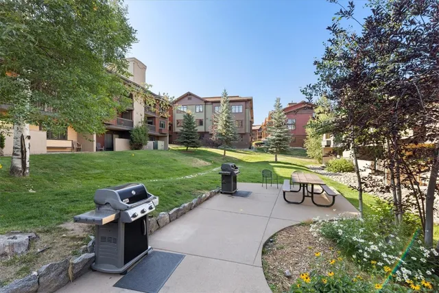 a view of house with a yard and potted plants