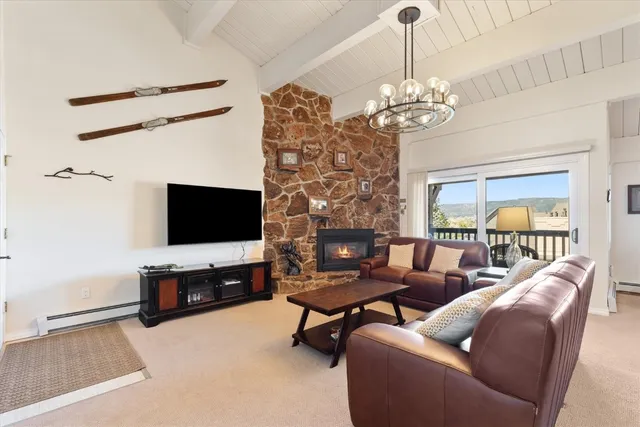 a living room with furniture a flat screen tv and a chandelier