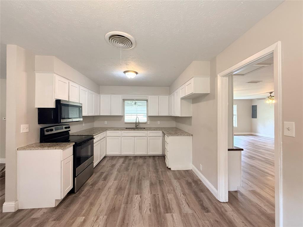 4075 Old Bonham Road Paris, TX 75460 - Photo 2 of 20 a kitchen with a sink a counter top space stainless steel appliances and cabinets