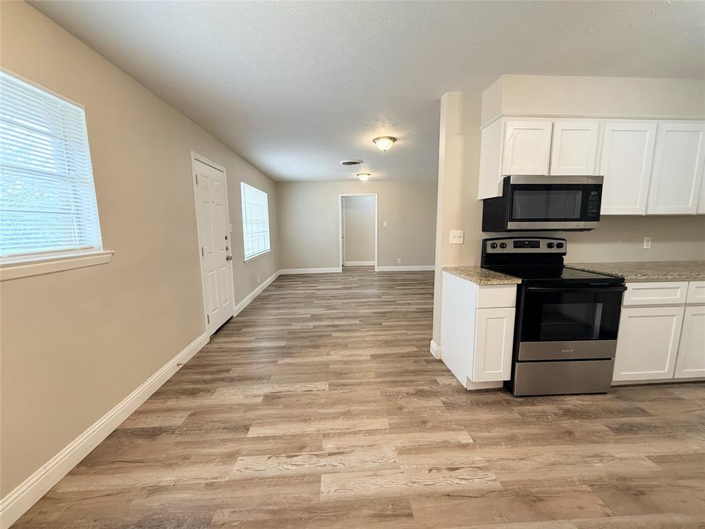 4075 Old Bonham Road Paris, TX 75460 - Photo 3 of 20 a kitchen with stainless steel appliances granite countertop a stove a sink and a microwave
