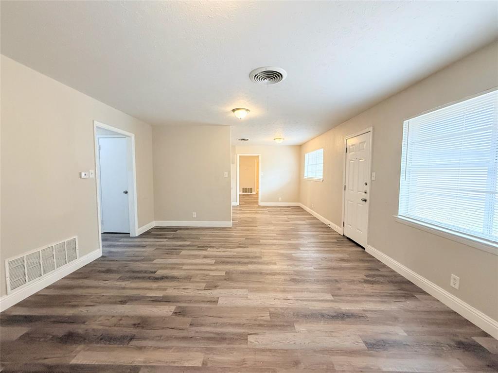 4075 Old Bonham Road Paris, TX 75460 - Photo 4 of 20 a view of an empty room with wooden floor and a window