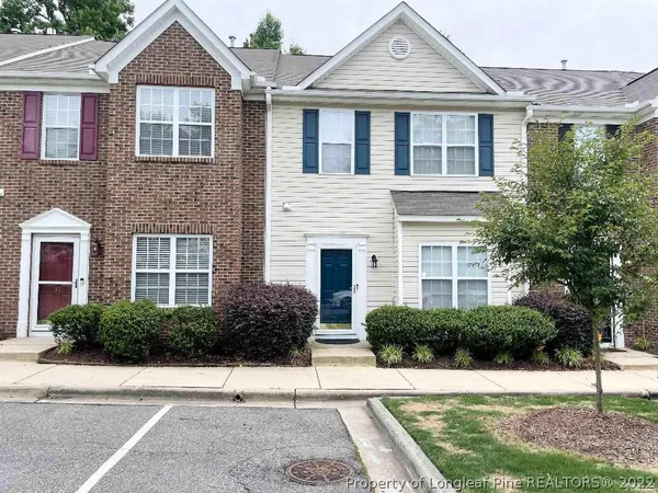 a front view of a house with a yard and potted plants