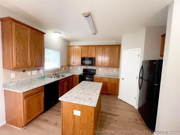 a kitchen with stainless steel appliances granite countertop refrigerator stove top oven a sink and dishwasher