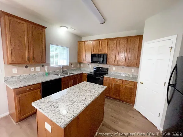 a kitchen with stainless steel appliances granite countertop a sink stove microwave and refrigerator