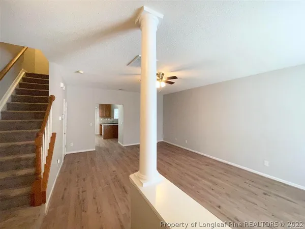 a view of a hallway with wooden floor and staircase