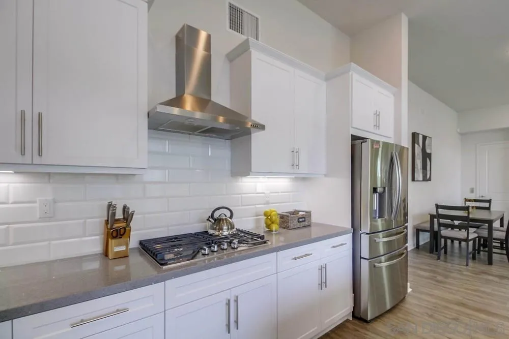 2035 Bravo Loop, Unit 6 Chula Vista, CA 91915 - Photo 14 of 39 a kitchen with stainless steel appliances granite countertop white cabinets a refrigerator and a stove