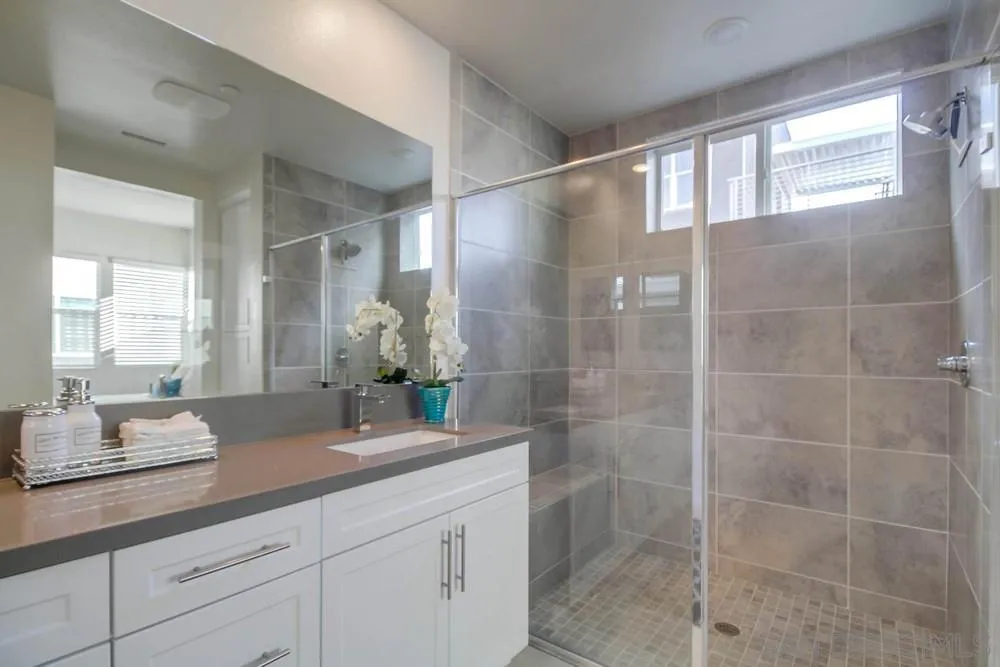 2035 Bravo Loop, Unit 6 Chula Vista, CA 91915 - Photo 21 of 39 a bathroom with a granite countertop sink a mirror and a shower