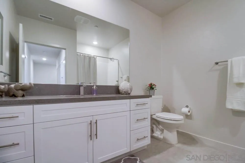 2035 Bravo Loop, Unit 6 Chula Vista, CA 91915 - Photo 24 of 39 a bathroom with a granite countertop sink a toilet and mirror