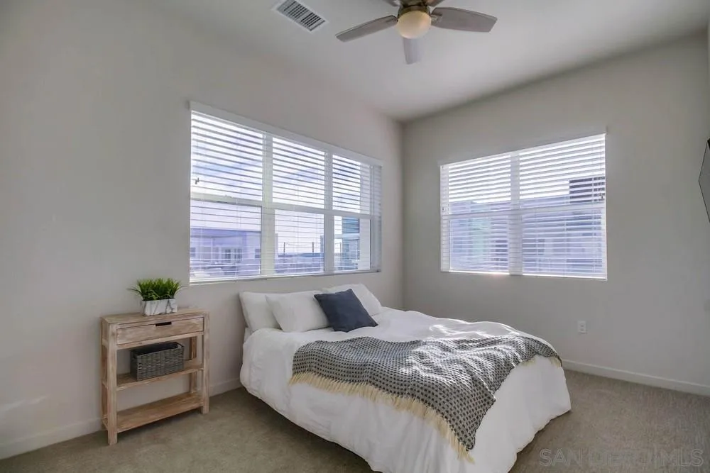 2035 Bravo Loop, Unit 6 Chula Vista, CA 91915 - Photo 27 of 39 a bedroom with a bed and a chandelier