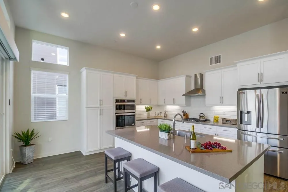2035 Bravo Loop, Unit 6 Chula Vista, CA 91915 - Photo 9 of 39 a kitchen with stainless steel appliances a sink a stove a refrigerator cabinets and wooden floor