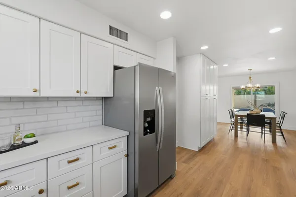 a kitchen with granite countertop white cabinets and stainless steel appliances