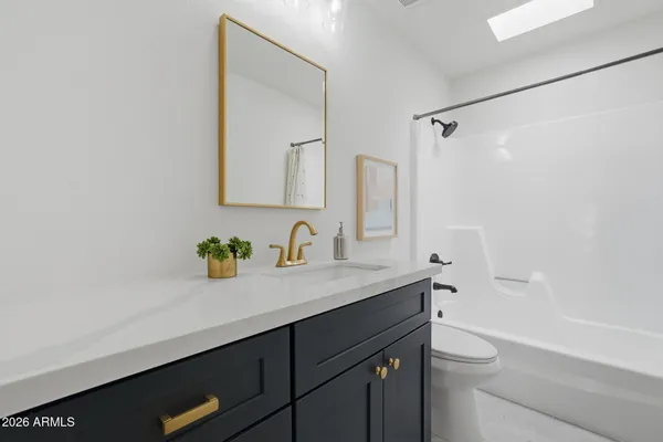 a bathroom with a granite countertop sink a toilet and a mirror