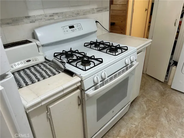 a kitchen with white cabinets and sink