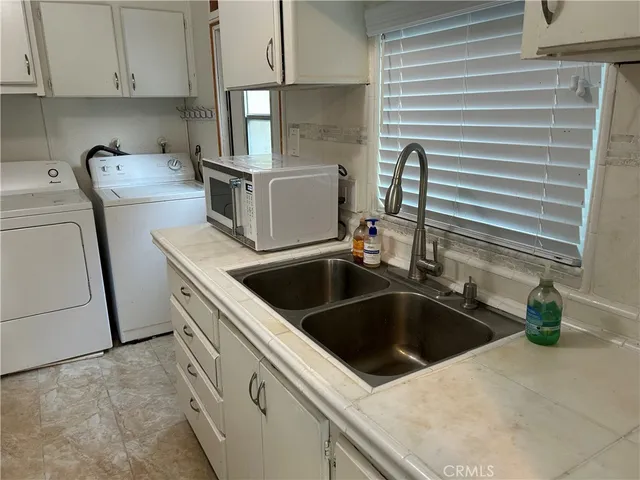 a kitchen with white cabinets and sink