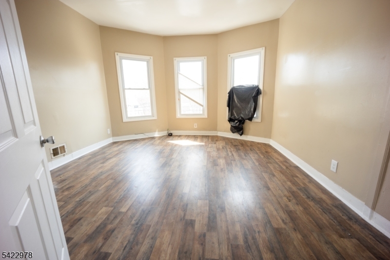 99 North 3rd Street Paterson, NJ 07522 - Photo 6 of 18 a room with wooden floor and a window