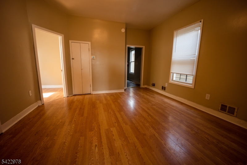 99 North 3rd Street Paterson, NJ 07522 - Photo 7 of 18 a view of an empty room with wooden floor and a window