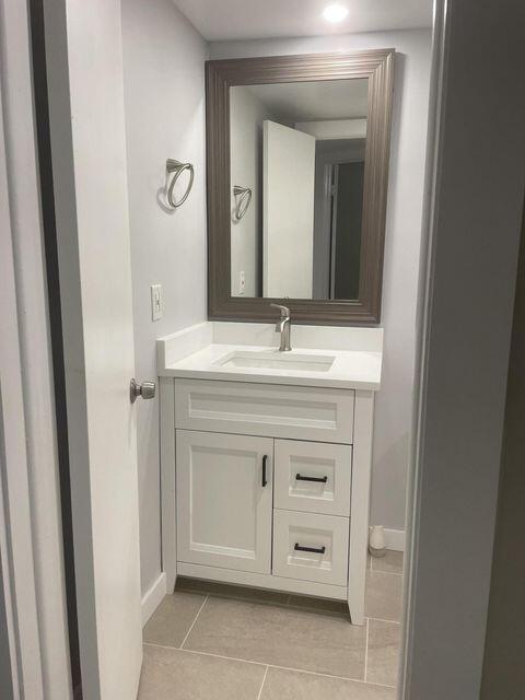 1638 Embassy Drive, Unit 102 West Palm Beach, FL 33401 - Photo 12 of 18 a bathroom with a sink vanity and mirror