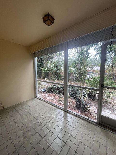 1638 Embassy Drive, Unit 102 West Palm Beach, FL 33401 - Photo 15 of 18 an empty room with large windows