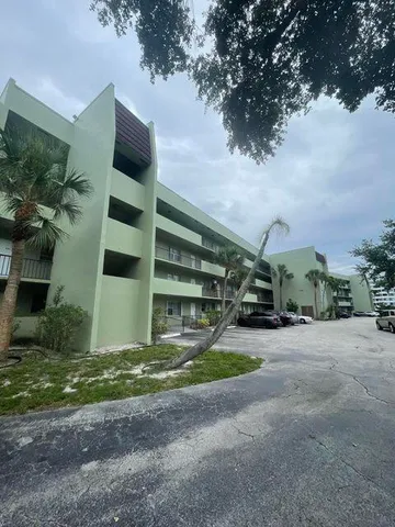 a view of a house with backyard and parking