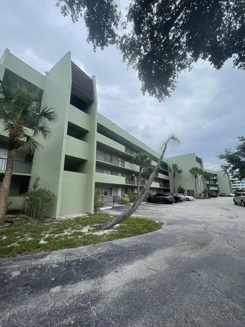 1638 Embassy Drive, Unit 102 West Palm Beach, FL 33401 - Photo 17 of 18 a view of a house with backyard and parking