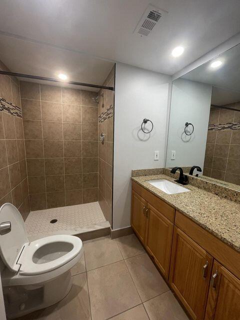 1638 Embassy Drive, Unit 102 West Palm Beach, FL 33401 - Photo 8 of 18 a bathroom with a double vanity sink toilet and shower