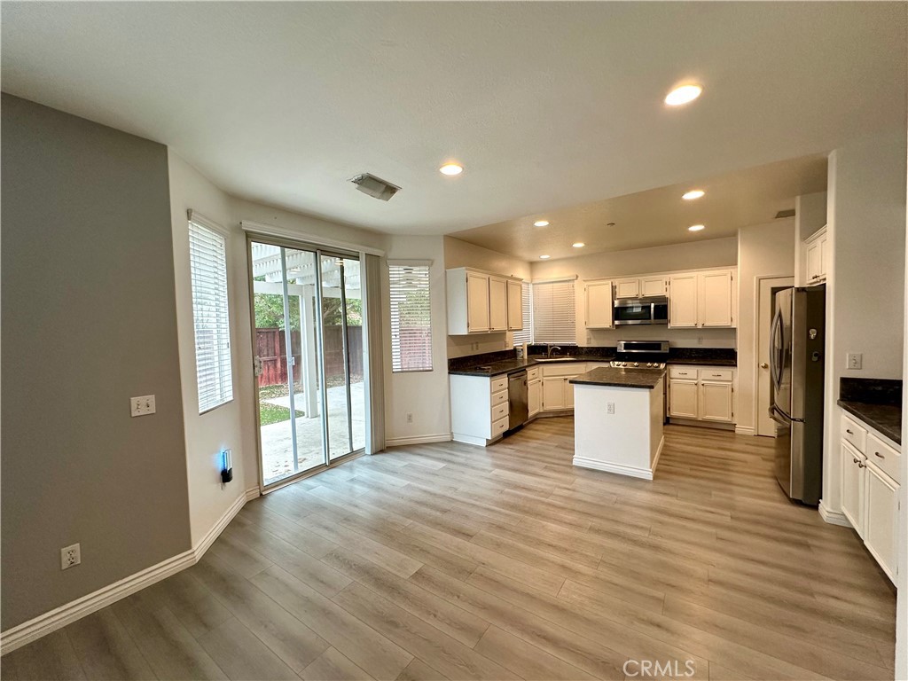 11146 Gardenhurst Court Riverside, CA 92505 - Photo 4 of 16 a large kitchen with stainless steel appliances kitchen island a large counter top and wooden floors