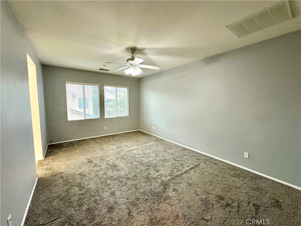 11146 Gardenhurst Court Riverside, CA 92505 - Photo 7 of 16 en empty room with windows and chandelier fan
