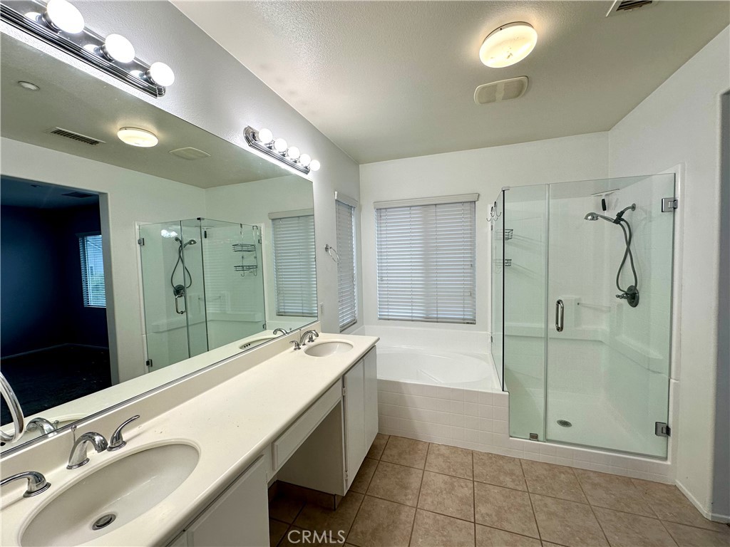 11146 Gardenhurst Court Riverside, CA 92505 - Photo 8 of 16 a bathroom with a double vanity sink large mirror and shower