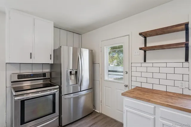 a kitchen with a refrigerator stove and cabinets