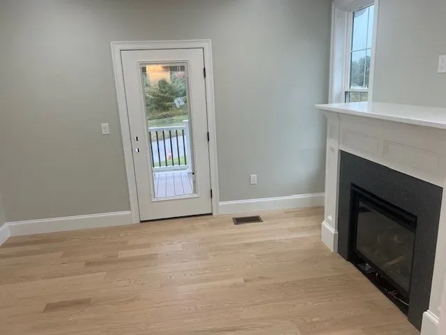 a view of an empty room with window and fire place