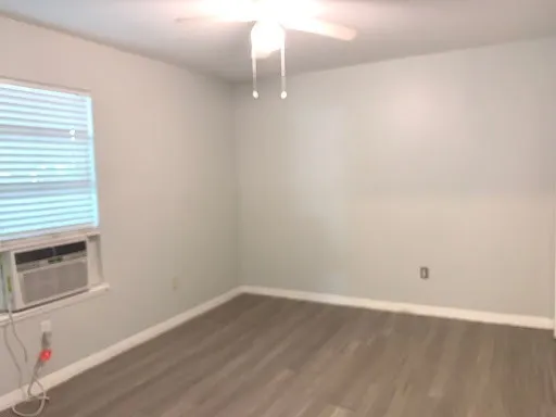 a room with wooden floor and windows